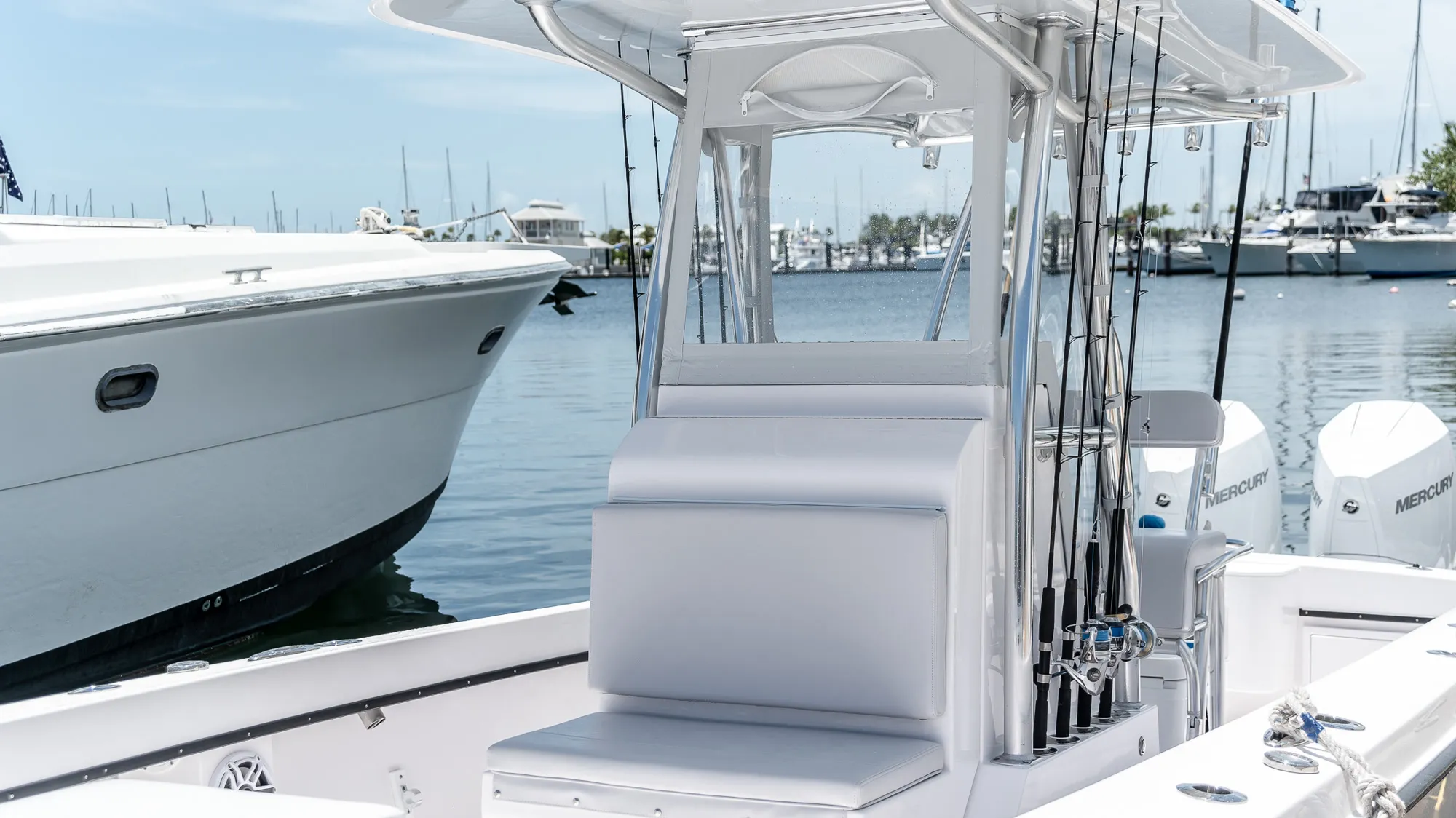 A centre-console charter boat tied up at a Key West marina, spinning rods racked beside the leaning post